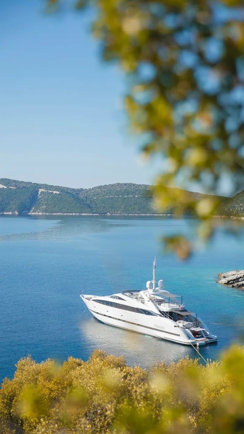 Yacht vor Anker in einer türkisfarbenen Bucht