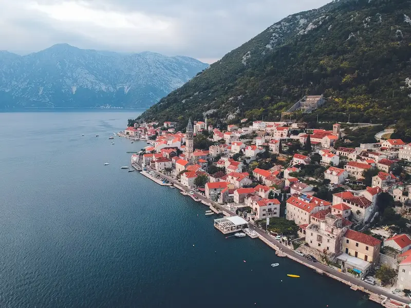 Perast vom Wasser aus: rote Dächer und die Berge der Bucht von Kotor